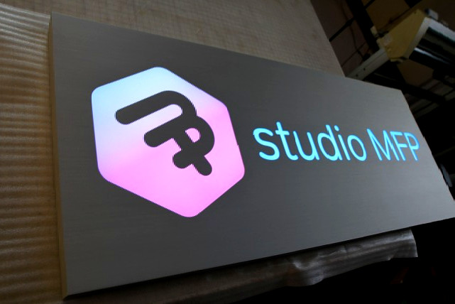 72" x 30" x 3" deep fabricated metal panel with reverse cut custom logo and lettering custom color printed face for gradient lighting effect