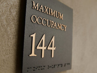 Bronze Metal ADA Plaque with raised brushed bronze text and background and ADA braille painted dark oxide