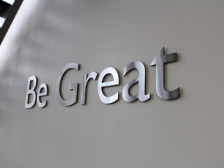 Cut Stainless Steel Letters in brushed finish installed on interior drywall lobby with spacers