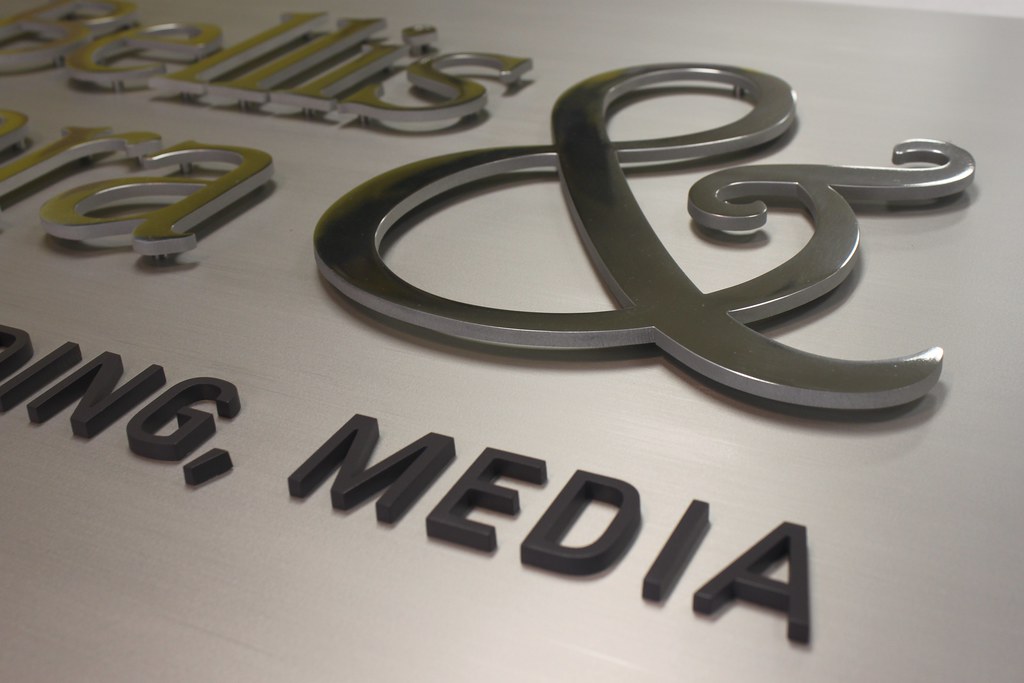 Detail raised metal letters assembled on brushed aluminum panel