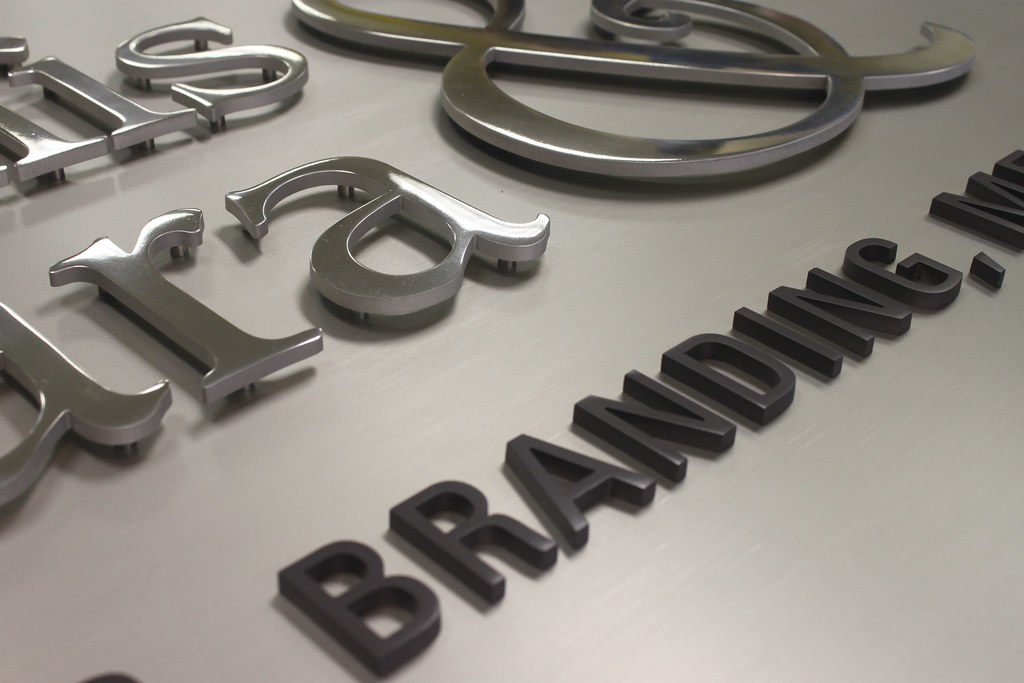 Detail raised metal letters assembled on brushed aluminum panel