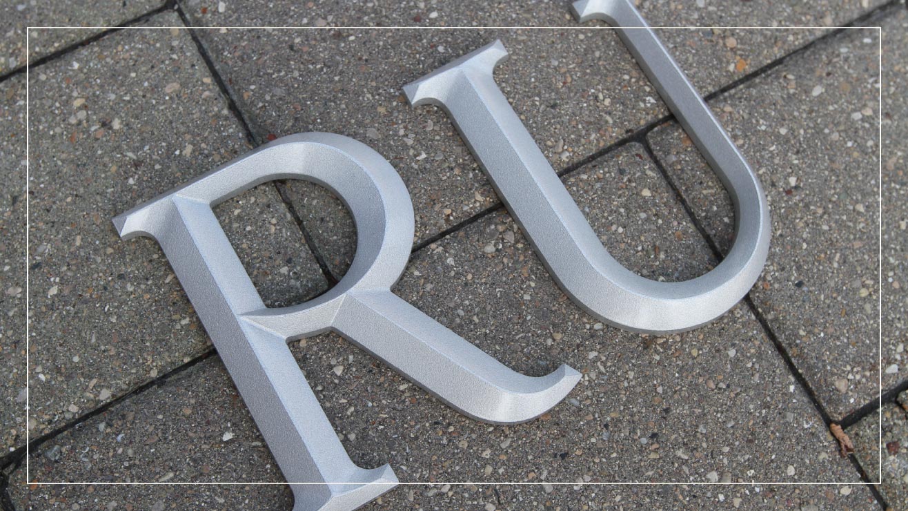 An example of cast aluminum lettering with the prismatic face on architectural font.