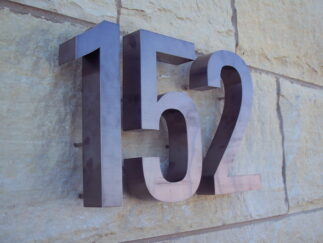 Fabricated titanium letters with dark oxidized finish