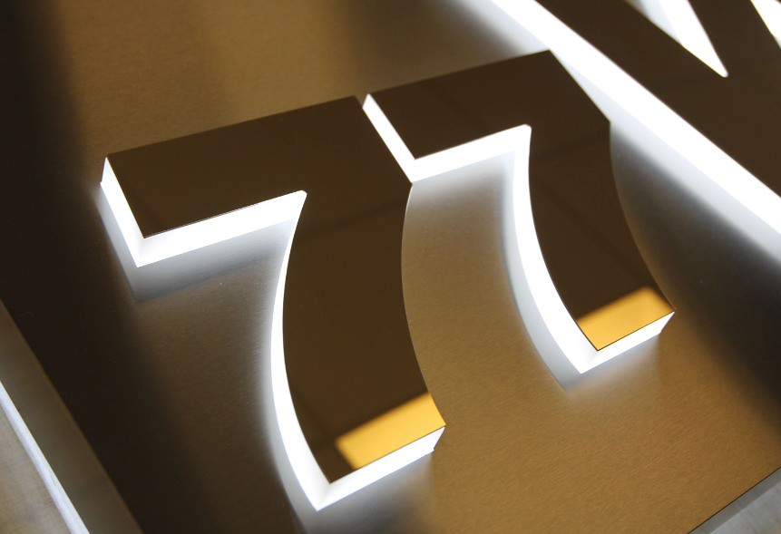 Lighted Lobby Sign Fabricated stainless steel panel with pushthru acrylic letters and graphics for edge lighting detail