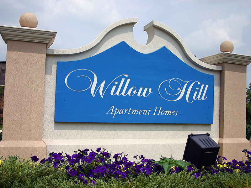 Neighborhood entrance sign with an exterior wood-carved panel, installed on custom high-density foam