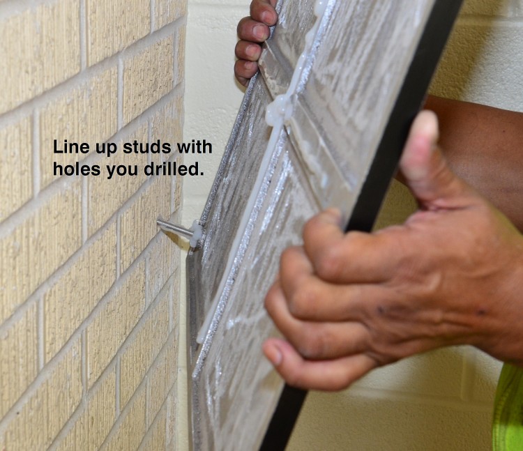 Line the studs with the holes drilled into the wall